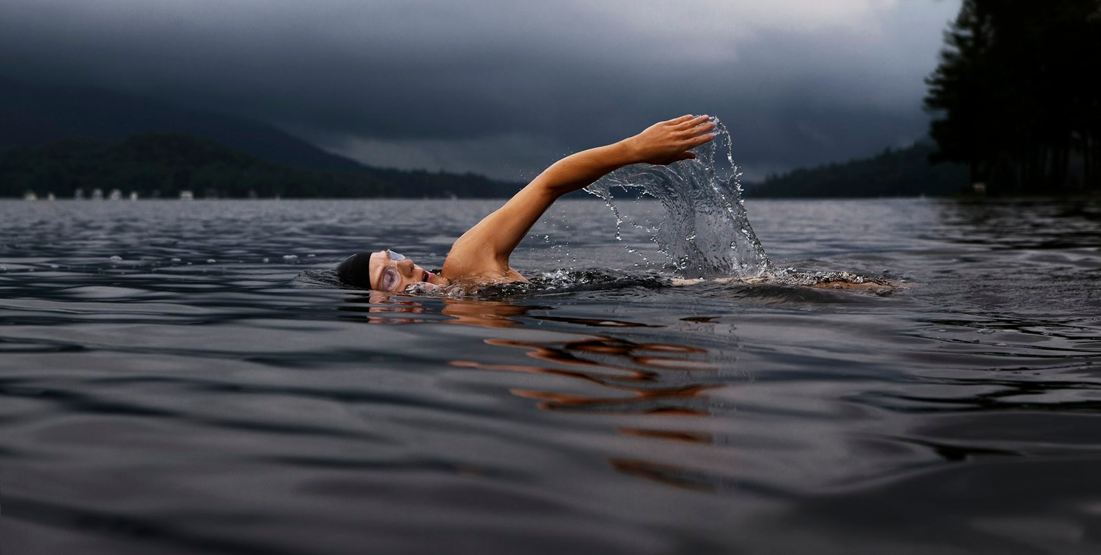 Nageur en eau libre sous un ciel d'orage