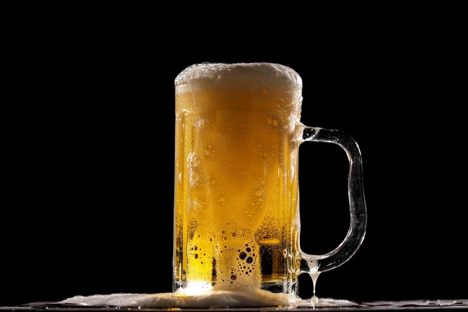 Chope de bière mousseuse sur fond noir