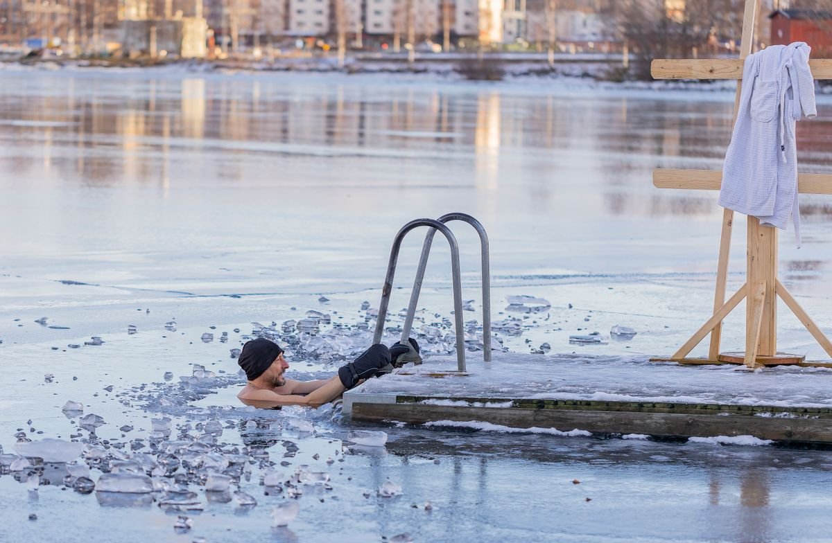 Baigneur dans une eau glacée près d'un ponton en hiver