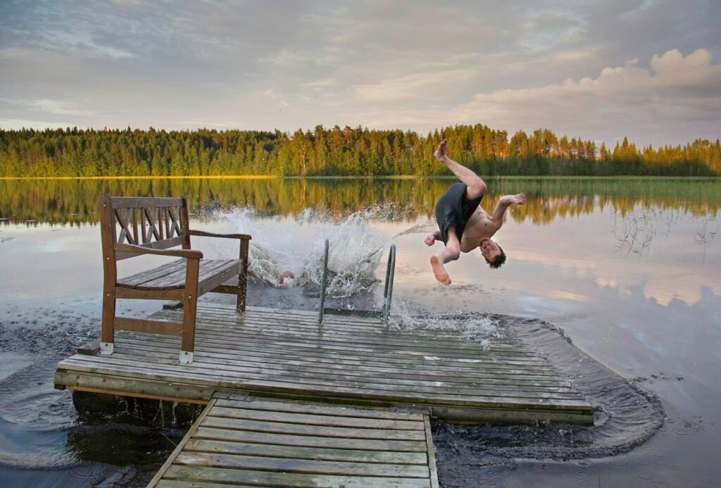 Plongeon dans un lac depuis un ponton en bois, par une soirée d'été