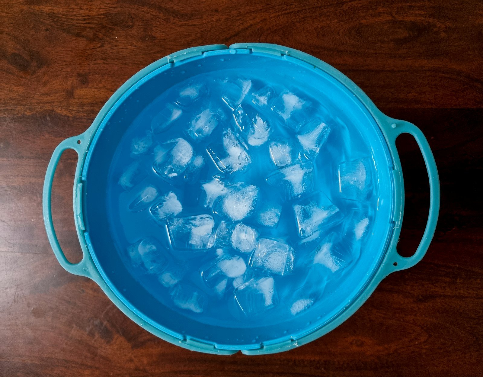 Glaçons flottant dans l'eau d'une bassine : refroidir un bain froid en été demande beaucoup de glace