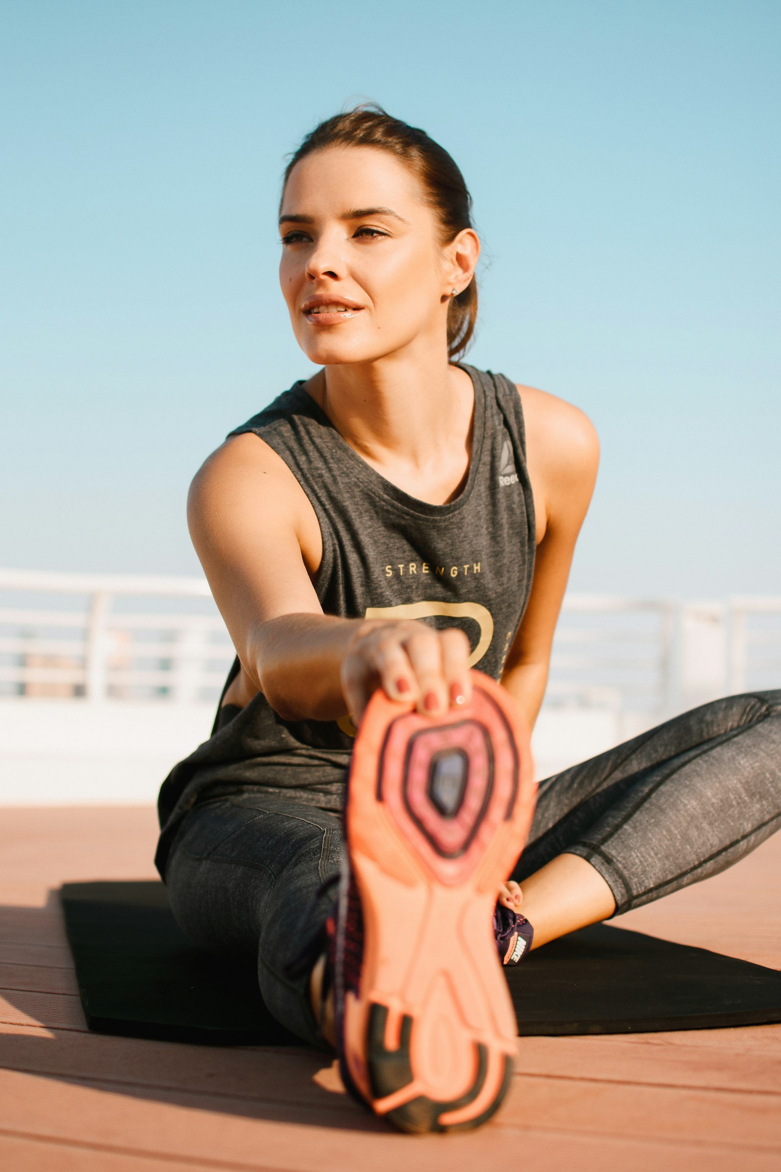 Sportive étirant la jambe sur un tapis