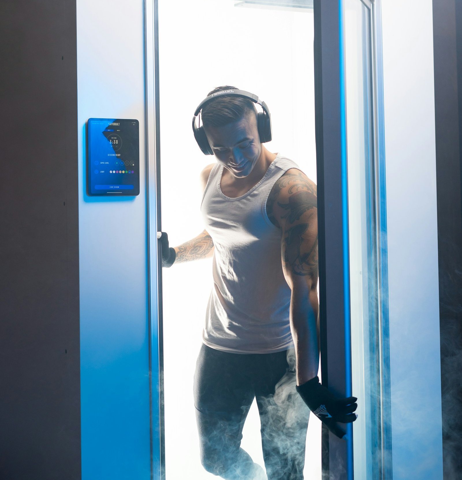 Sportif sortant d'une cabine de cryothérapie corps entier entouré de vapeur froide