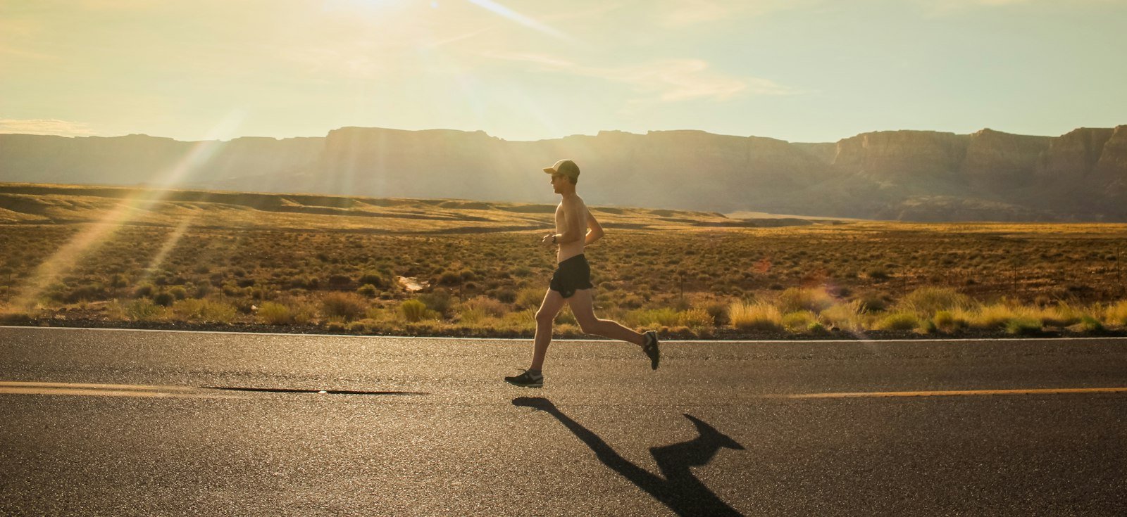 Coureur sur une route au lever du jour, séance d'entraînement matinale