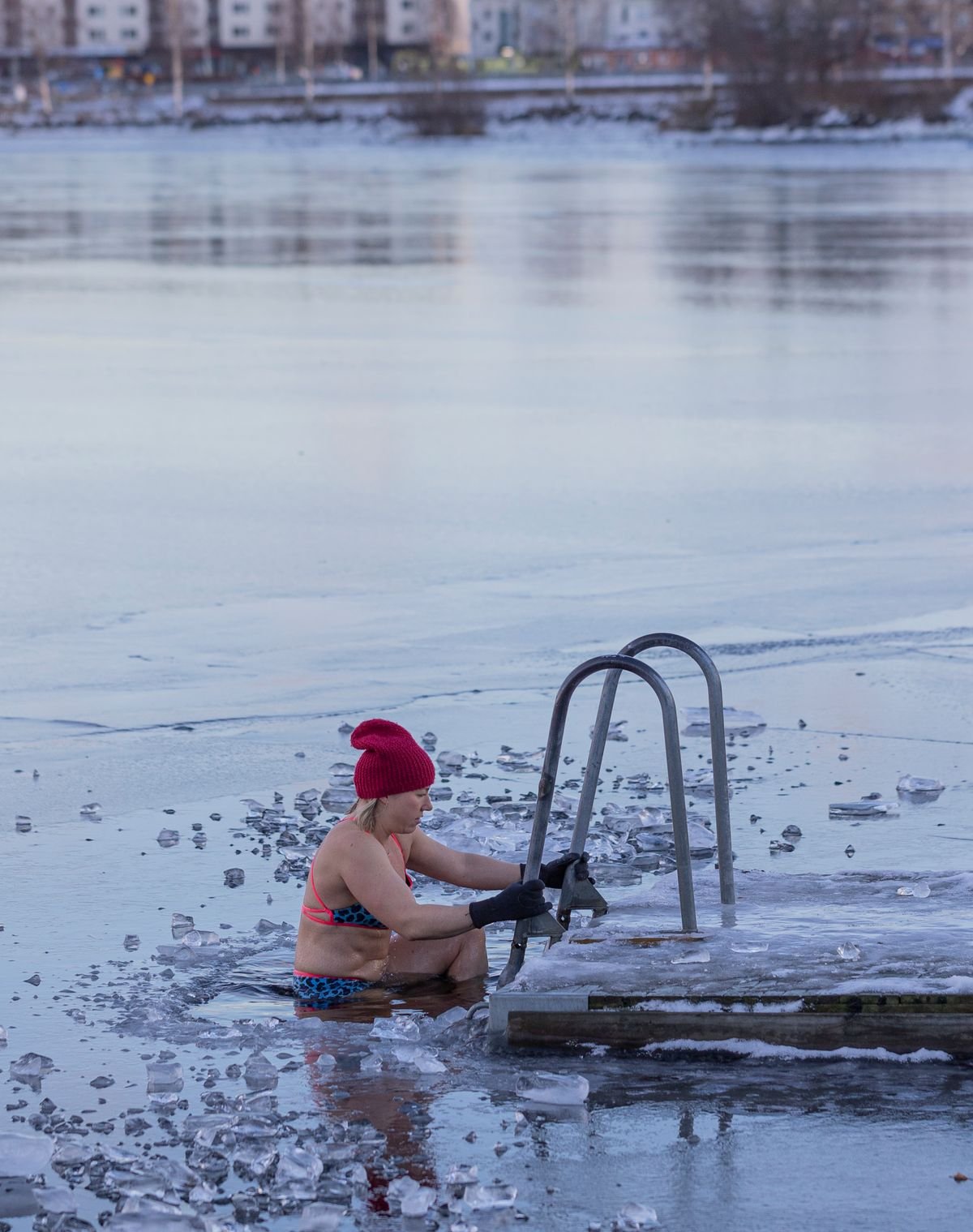 Femme entrant dans une eau glacée par une échelle