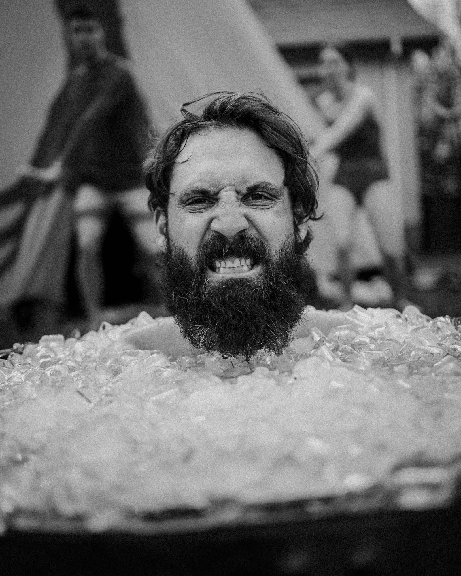 Homme immergé jusqu'au cou dans un bain de glace, mâchoires serrées sous l'effet du froid