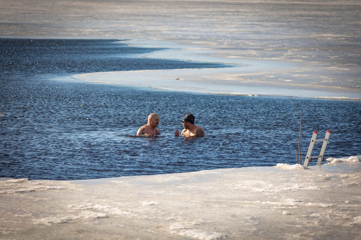 Deux personnes en immersion dans une eau froide en hiver