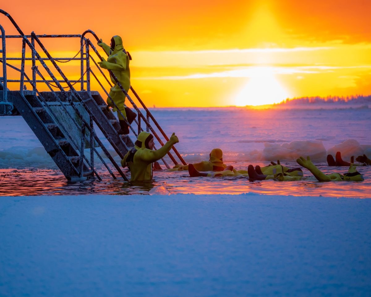 Groupe pratiquant l'immersion en eau froide au lever du soleil