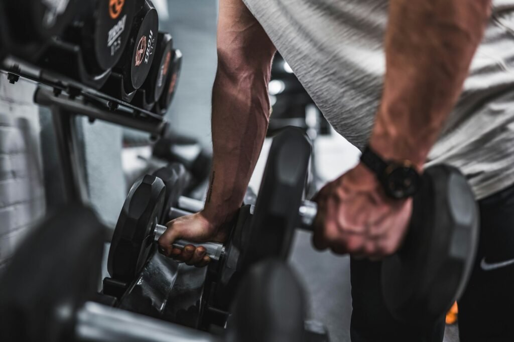 Sportif saisissant des haltères sur un rack en salle de musculation