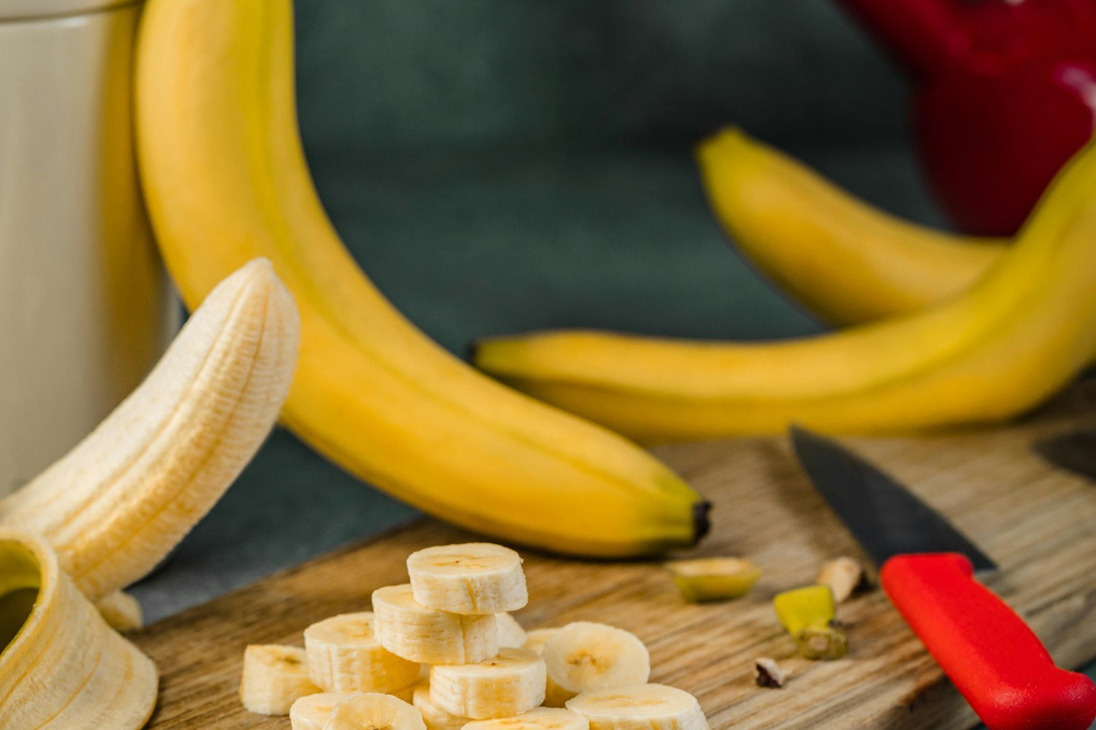 Bananes entières et rondelles de banane sur une planche à découper, collation avant le sport
